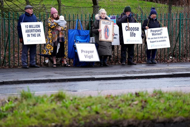 Five protesters holding up placards