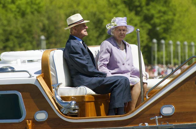 The Queen and the Duke of Edinburgh ride on an Australian Navy barge during a trip on Lake Burley Griffin in Canberra (Arthur Edwards/The Sun/PA)