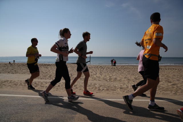 Joggers run along sea front