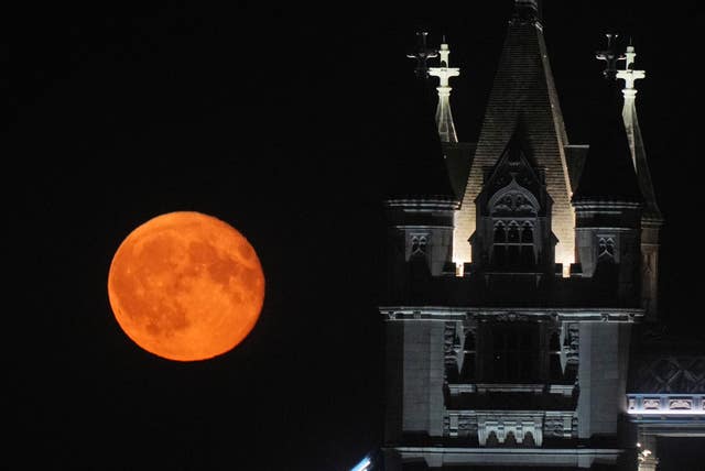 A waning gibbous moon rises over Tower Bridge in London on August 20