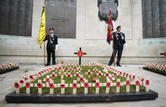 Standard bearers stand behind crosses planted in remembrance at the WWI memorial, Guildhall Square, in Portsmouth, as people gather to remember the war dead on Armistice Day 