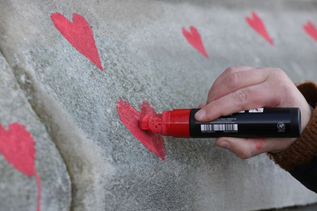 Members of bereaved families painted red hearts on the memorial 