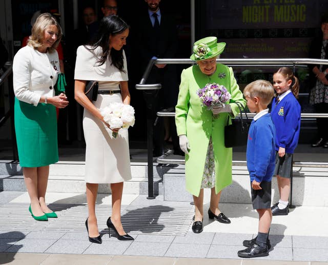 The Queen and Meghan are given flowers