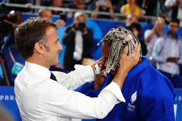 Emmanuel Macron putting a medal around the neck of Romane Dicko