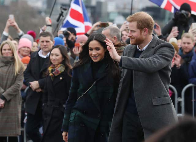 Royal aide Amy Pickerill (left) looks on as Meghan Markle and Prince Harry meet well-wishers during their recent visit to Edinburgh. (Andrew Milligan/PA)
