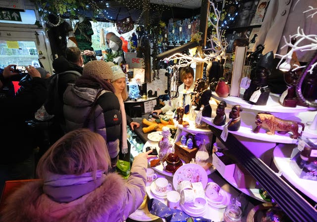 Customers in a shop with laden shelves