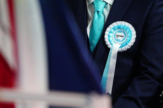 A person wearing a Reform UK rosette 