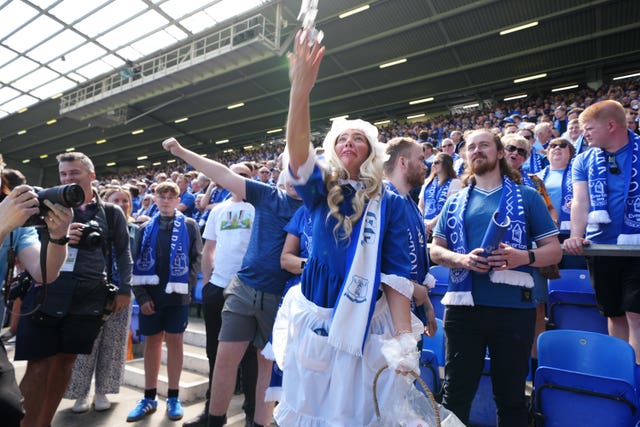 The Everton Toffee Lady throws sweets into the crowd before kick-off 