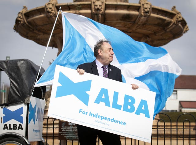 Alex Salmond holding an Alba Party sign