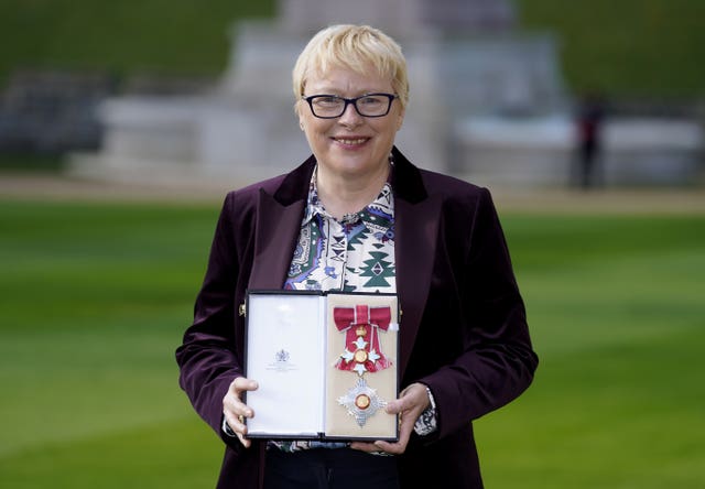 A woman holds a box with insignia in it