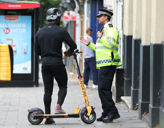 A police officer speaks to an e-scooter rider