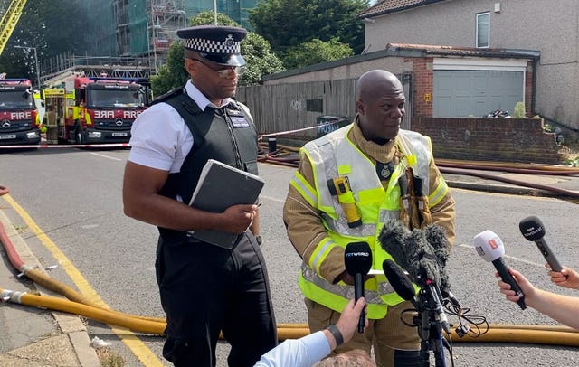 Assistant Commissioner of the London Fire Brigade Patrick Goulbourne, right, speaks at a press conference in Dagenham, London