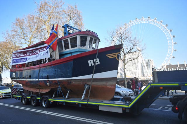 A fishing boat is towed through Westminster 