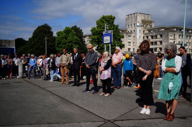 People take part in a minute’s silence outside Plymouth Guildhall in memory of the five people killed by Davison 