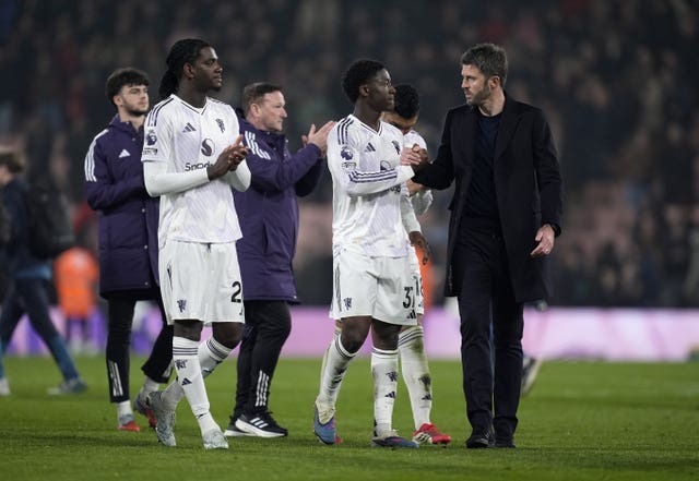 Manchester United manager Michael Carrick (right) and Kobbie Mainoo (centre).