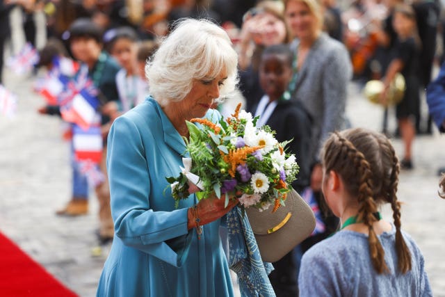 The Queen accepts a bouquet of flowers on her arrival in Bordeaux