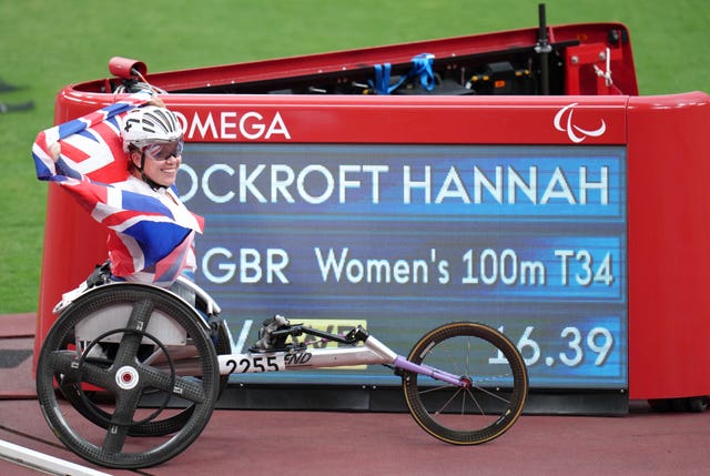 Briton Hannah Cockroft poses with the scoreboard showing her new world record
