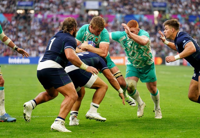 South Africa’s Pieter-Steph du Toit, centre, takes on the tackle of Sione Tuipulotu on his way to scoring against Scotland in the 2023 World Cup