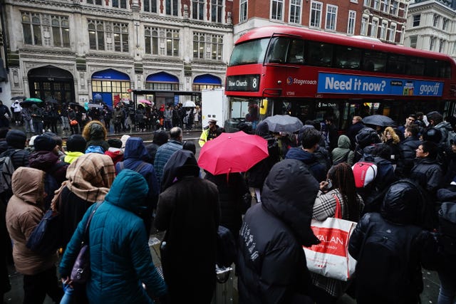 People wait to get on a bus at Liverpool Street station 