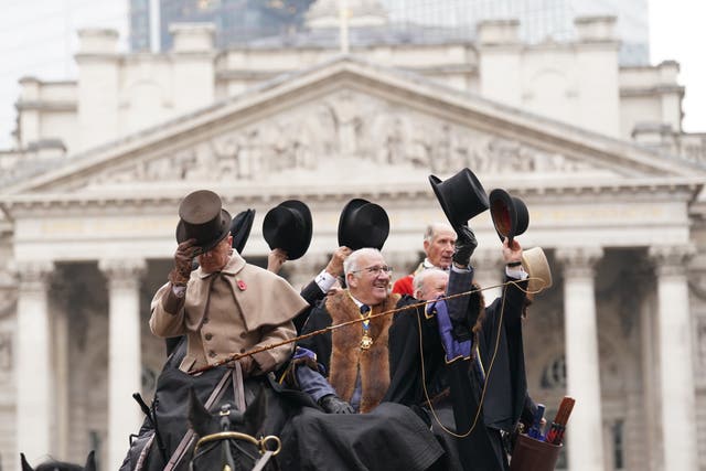 People dressed in period costumes tip their hats during the Lord Mayor’s Show 2024 