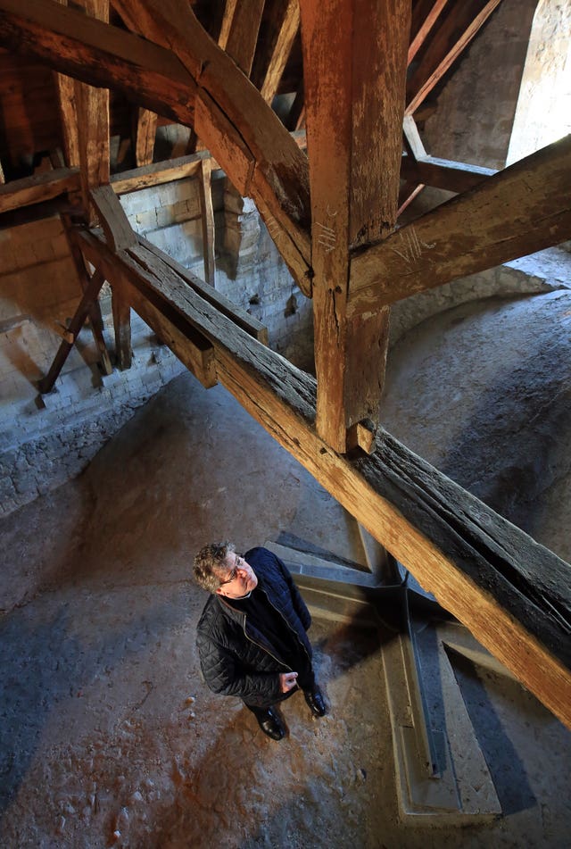 The Very Reverend Stephen Waine looks at the medieval timbers in the roof (Gareth Fuller/PA)