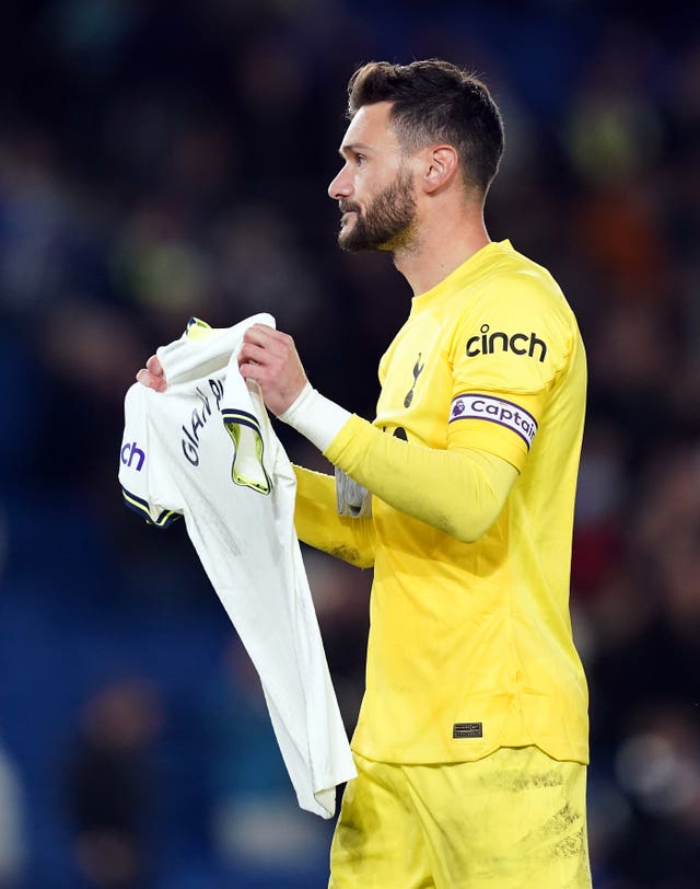 Hugo Lloris holds up a shirt with a tribute in memory of fitness coach Gian Piero Ventrone