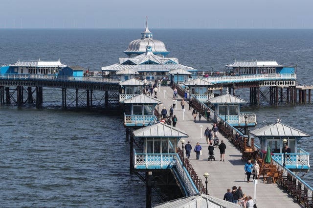 People walk along the pier in Llandudno,