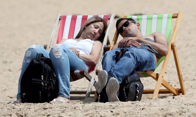 A couple enjoy the warm weather on the beach in Margate