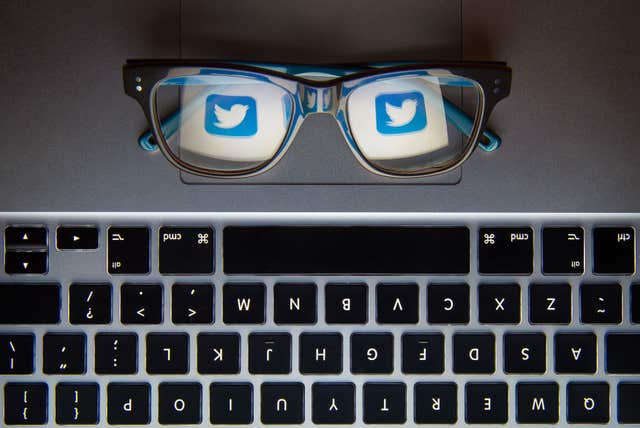 Twitter logo seen reflected in a pair of glasses resting on a laptop (Dominic Lipinski/PA