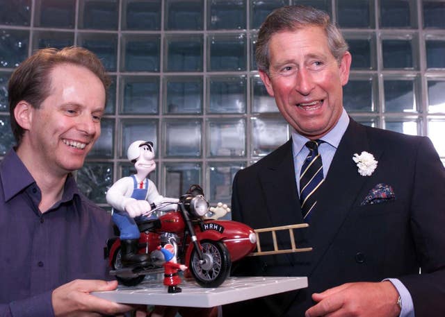The then-Prince of Wales accepting a model of animated characters Wallace and Gromit from Aardman creator Nick Park in 2001