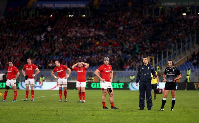 The Wales players wait as the referee Mathieu Raynal (right) watches a replay on the big screen