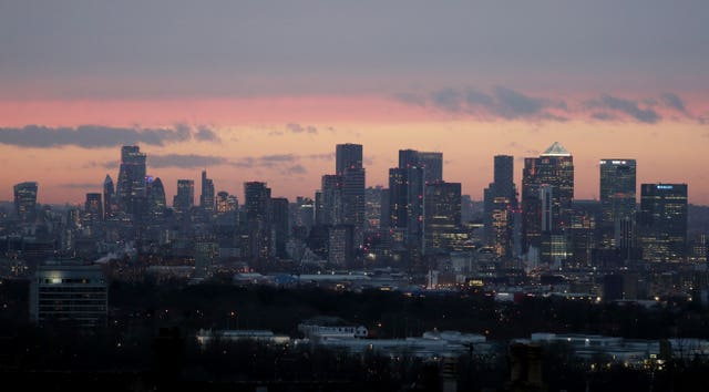 Canary Wharf and the City of London skyline at sunset as seen from Shooters Hill, London (Jonathan Brady/PA)