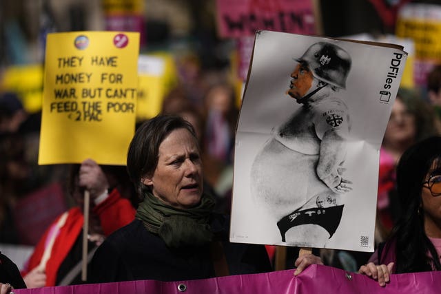 A woman holding a poster of Donald Trump in a helmet 