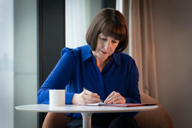 Rachel Reeves sitting at a table and writing