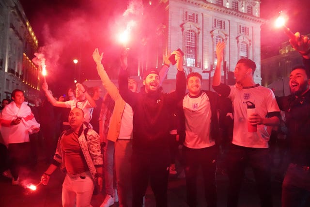Fans let off flares as they celebrate in Piccadilly Circus, central London, on Wednesday