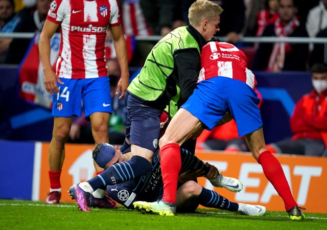 Oleksandr Zinchenko (centre) tries to stop Atletico Madrid’s Stefan Savic from dragging Phil Foden off the pitch 
