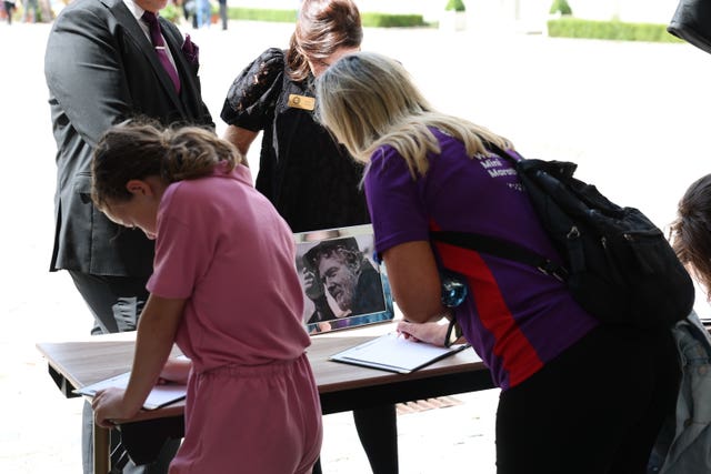 People signing condolence books