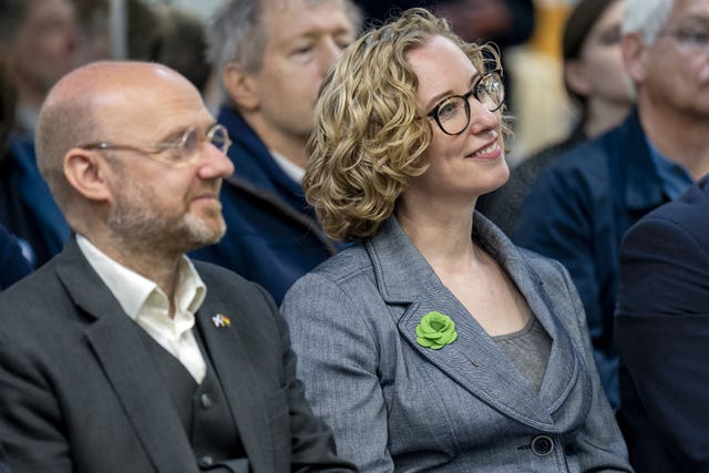 Patrick Harvie and Lorna Slater smiling while sitting in an audience