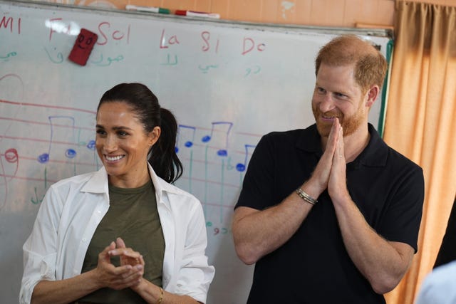 The Duke and Duchess of Sussex listen to a music class 