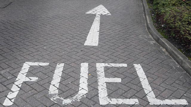 A sign pointing towards a fuel station