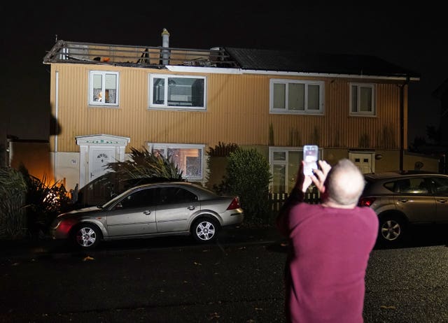 A homeowner, who lost the roof of his house in strong winds, takes a picture in Blackhall, County Durham