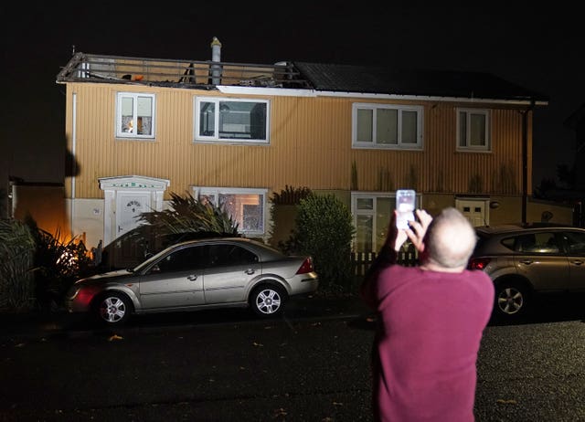 A homeowner, who lost the roof of his house in strong winds, takes a picture in Blackhall, County Durham 