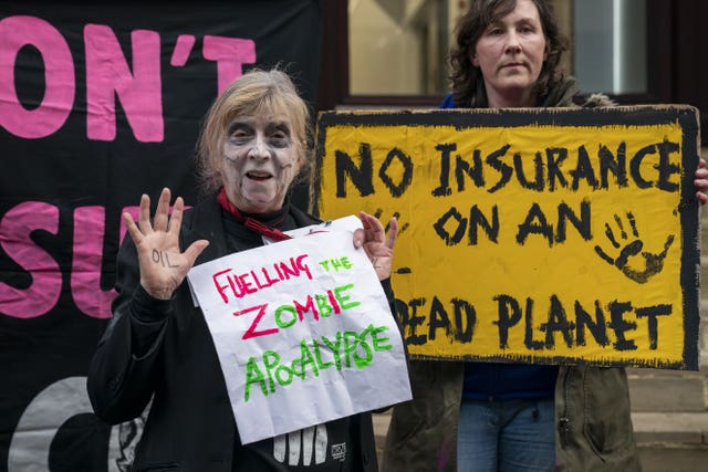 Protesters holding signs reading 'Fuelling the zombie apocalypse'