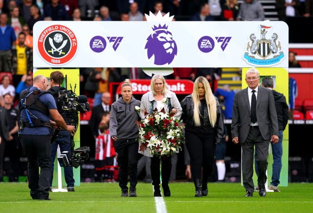 Former Sheffield United player Tony Currie, Sheffield United women’s Sophie Barker and Maddy Cusack’s mum and sister walk on to the pitch to lay a wreath