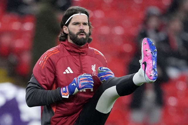 Liverpool goalkeeper Alisson Becker kicks his left leg high in a warm-up