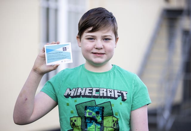Leo McGeough, 12, with his vaccination card