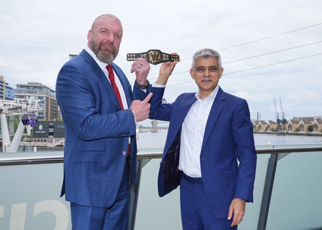 Mayor of London Sadiq Khan (right) holds aloft a gifted mini replica WWE Championship belt, with Paul “Triple H” Levesque
