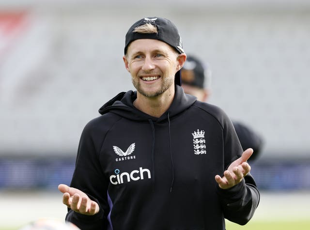 Joe Root, wearing a cap back-to-front, smiles during a net session