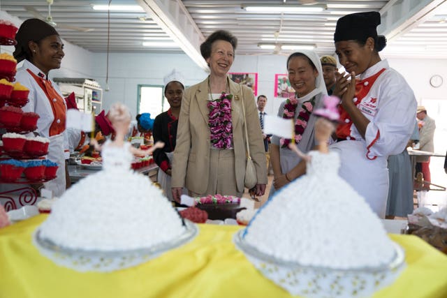 The Princess Royal looks at Barbie cakes during a visit to the Cooking Laboratory at Caritas Technical Secondary School