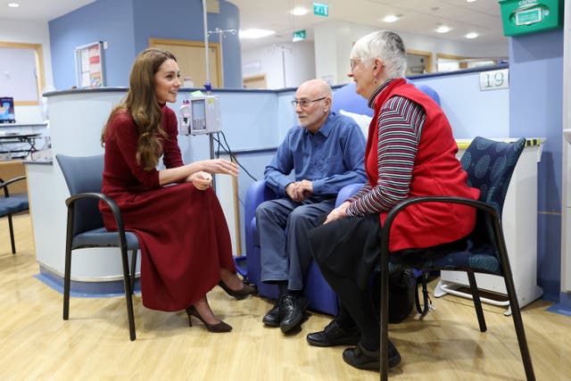 Kate sits in a medical treatment unit and chats to patients and their families